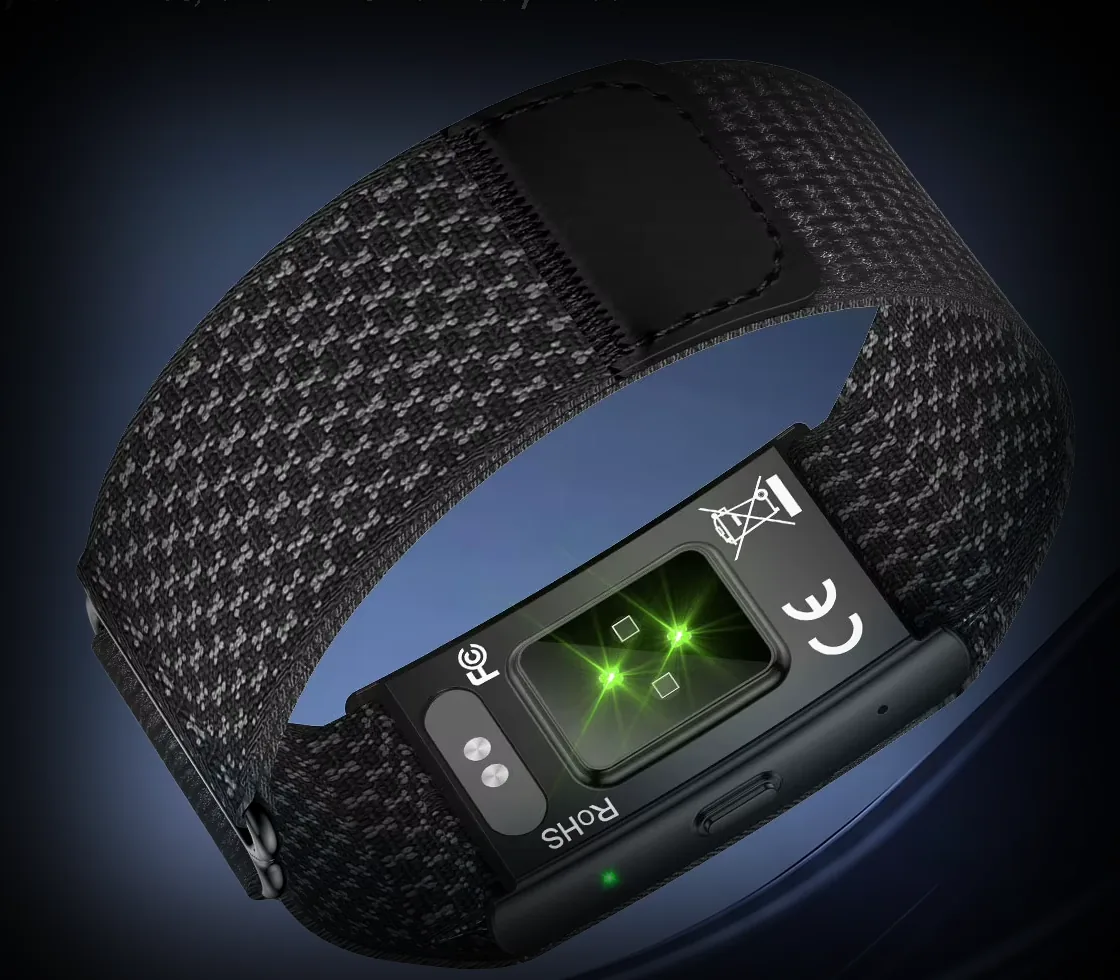 The underside of the Kira Band module: an optical sensor window with four green LEDs lit, beside the magnetic charging contacts
